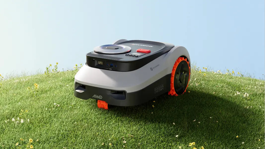 Segway Navimow robotgräsklippare med AWD står på gräsmattan under en klar himmel.