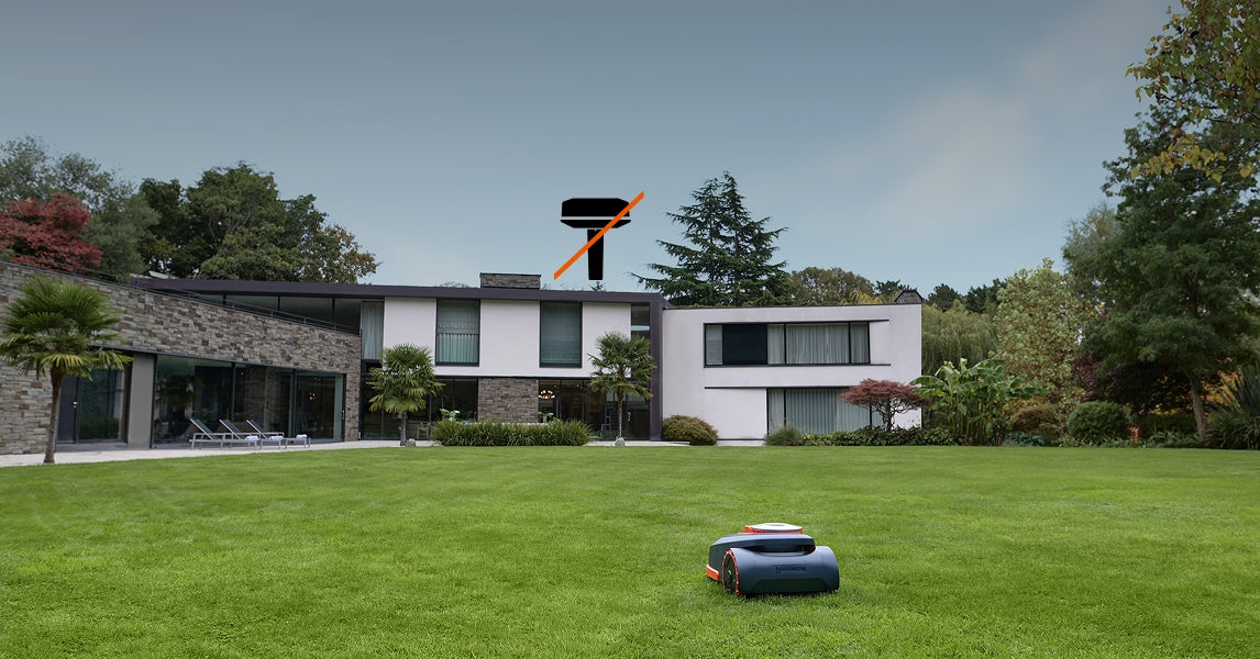Navimow i105E robotgräsklippare på gräsmattan framför en stor modern villa.