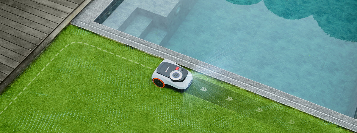 Navimow i105E robotgräsklippare klipper gräsmattan intill en stor blå pool.